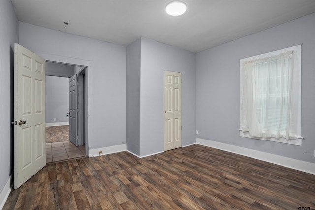 unfurnished bedroom featuring a closet and dark hardwood / wood-style flooring