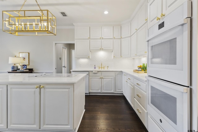 kitchen with white double oven, visible vents, white cabinets, hanging light fixtures, and dishwasher