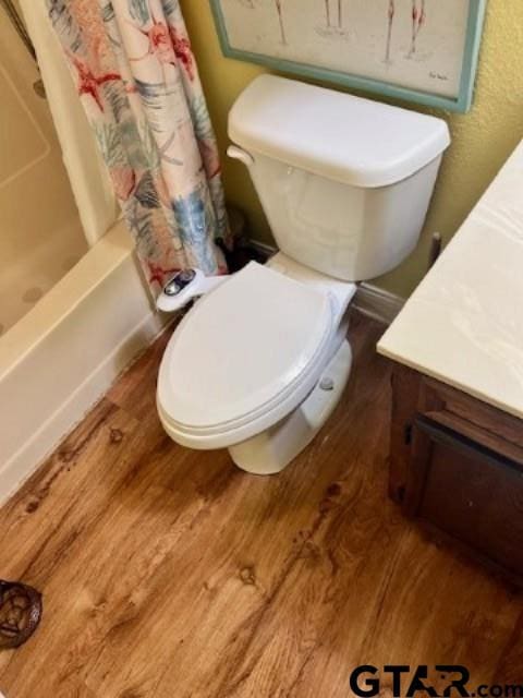 full bathroom featuring wood-type flooring, vanity, toilet, and shower / bath combo