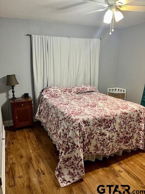 bedroom with wood-type flooring and ceiling fan