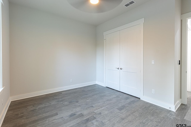 unfurnished bedroom featuring ceiling fan, wood-type flooring, and a closet