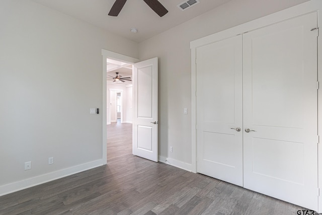 unfurnished bedroom with ceiling fan, wood-type flooring, and a closet