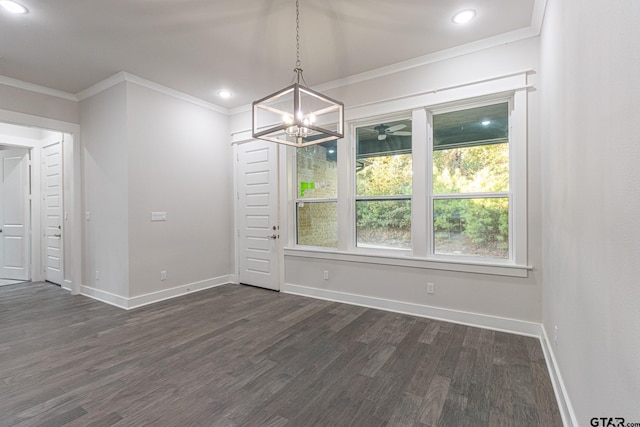 unfurnished dining area with dark wood-type flooring, ornamental molding, and a chandelier