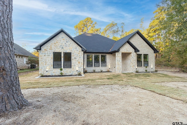 french country inspired facade featuring a front lawn