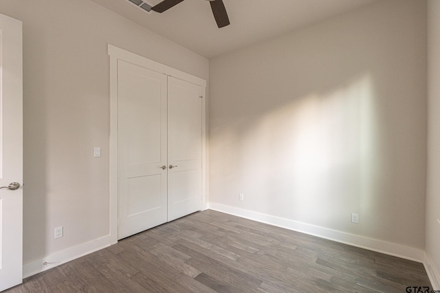 unfurnished bedroom with wood-type flooring, a closet, and ceiling fan