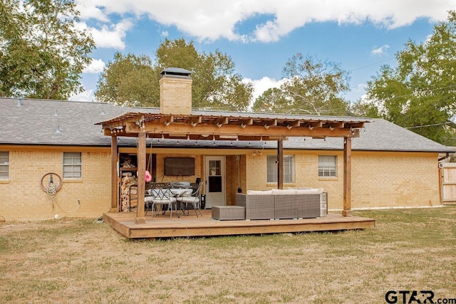 rear view of house featuring a wooden deck, a pergola, a lawn, and an outdoor hangout area