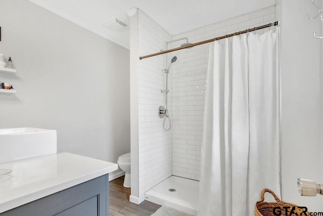 bathroom featuring curtained shower, wood-type flooring, and toilet