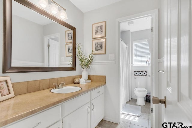 bathroom with vanity, tile patterned flooring, and toilet