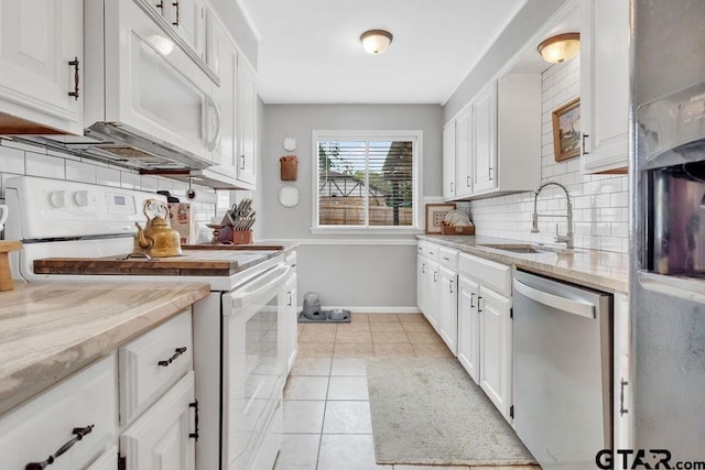 kitchen with white cabinets, decorative backsplash, sink, light tile patterned floors, and white appliances