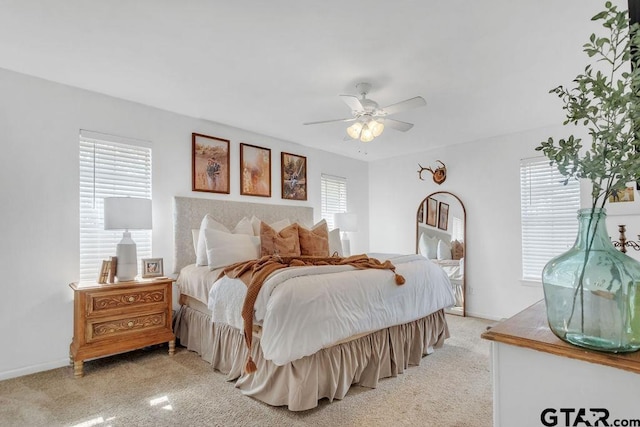 bedroom with multiple windows, light colored carpet, and ceiling fan