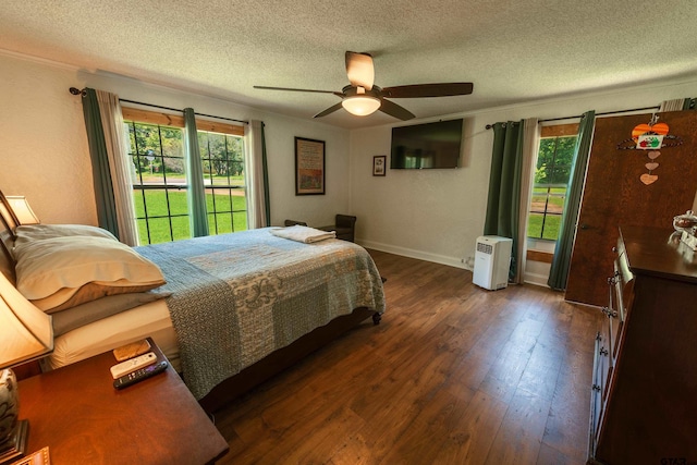 bedroom with ceiling fan, a textured ceiling, and dark hardwood / wood-style floors