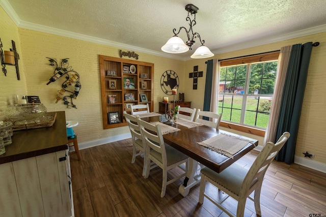 dining room featuring dark wood-type flooring, a textured ceiling, a notable chandelier, and ornamental molding