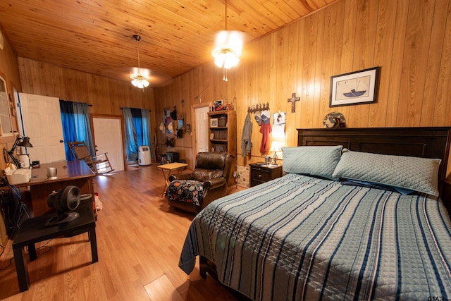 bedroom with wooden walls, wooden ceiling, and light hardwood / wood-style flooring