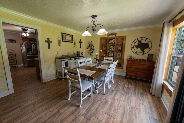 dining space with ornamental molding, ceiling fan with notable chandelier, a textured ceiling, and dark hardwood / wood-style floors