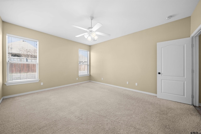 carpeted spare room with ceiling fan