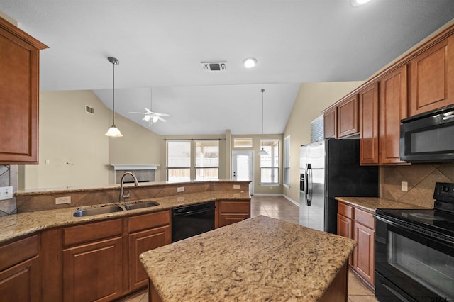 kitchen featuring light stone counters, sink, vaulted ceiling, and black appliances