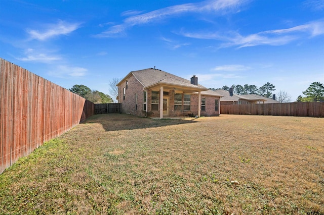 rear view of house featuring a lawn