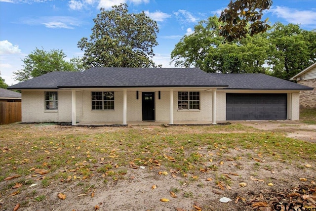 ranch-style house with a garage, fence, covered porch, and brick siding