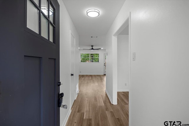hall featuring baseboards and wood finished floors