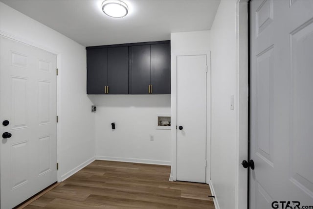 washroom with cabinet space, hookup for a washing machine, electric dryer hookup, baseboards, and wood finished floors