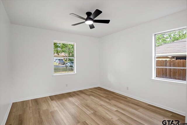 empty room featuring light wood-style floors, baseboards, and ceiling fan