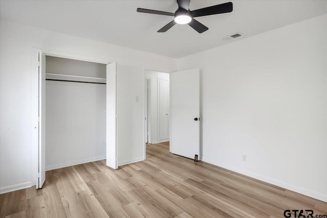 unfurnished bedroom with ceiling fan, light wood finished floors, baseboards, visible vents, and a closet