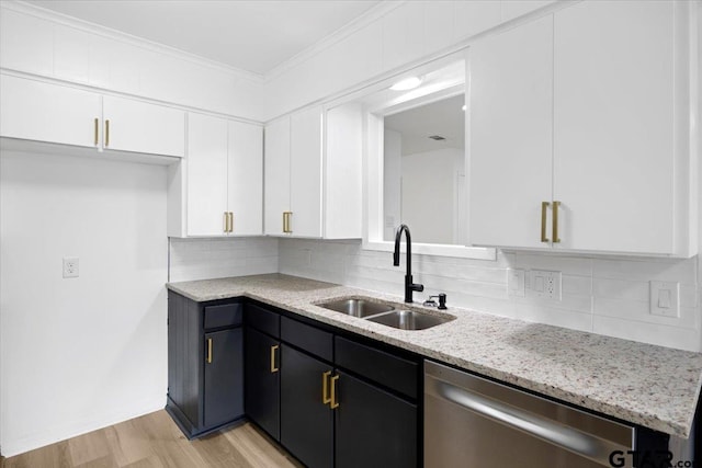 kitchen with stainless steel dishwasher, light stone countertops, light wood-type flooring, white cabinets, and a sink