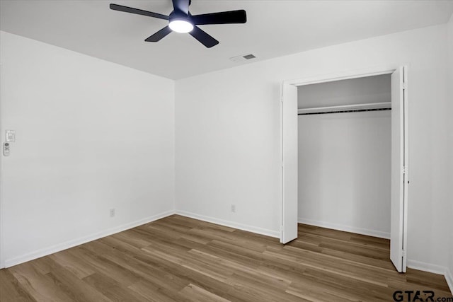 unfurnished bedroom featuring visible vents, baseboards, and wood finished floors