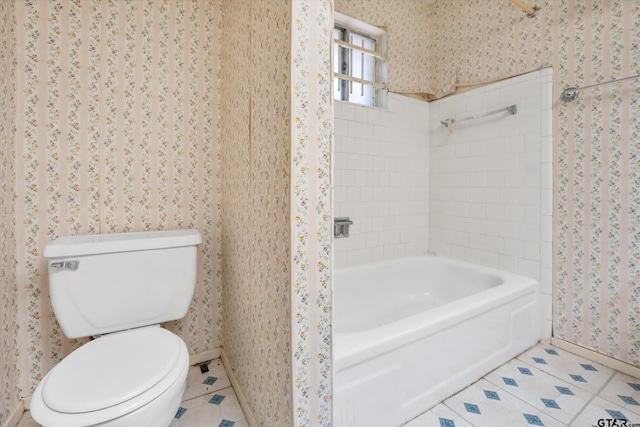 12411 Drifting Winds Dr, Houston, TX 77044 - bathroom with tile patterned flooring, wallpapered walls, toilet, baseboards, and tub / shower combination