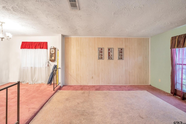 12411 Drifting Winds Dr, Houston, TX 77044 - spare room featuring carpet floors, healthy amount of natural light, a textured ceiling, a chandelier, and baseboards