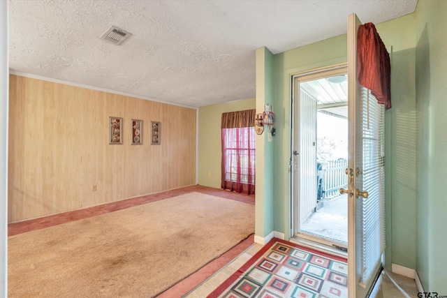12411 Drifting Winds Dr, Houston, TX 77044 - carpeted foyer entrance featuring a textured ceiling, baseboards, and wood walls