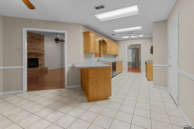 kitchen with black dishwasher, a ceiling fan, light tile patterned floors, light countertops, and a peninsula