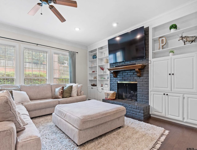 living room featuring a brick fireplace, ornamental molding, dark hardwood / wood-style floors, ceiling fan, and built in features