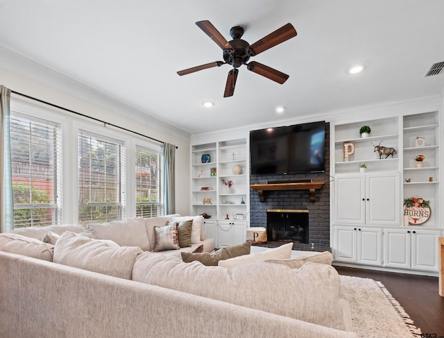 living room with dark wood-type flooring, ornamental molding, ceiling fan, and a brick fireplace