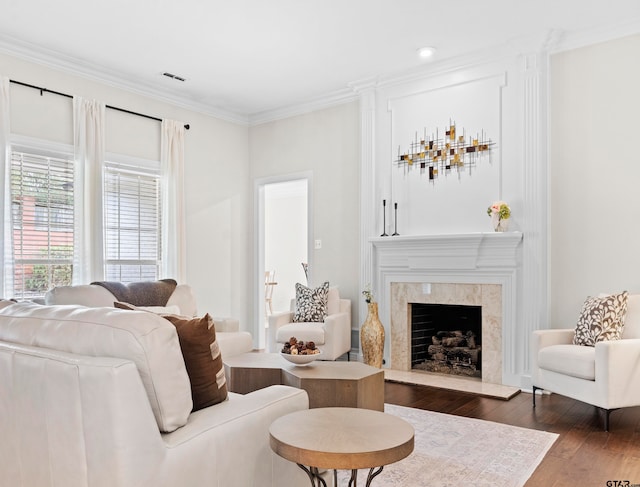 living room with dark hardwood / wood-style flooring, a tile fireplace, and crown molding