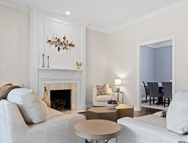 living room featuring ornamental molding, a premium fireplace, and wood-type flooring