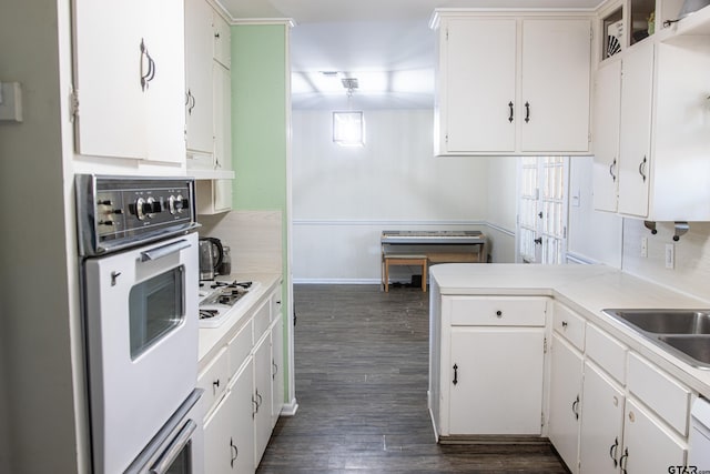 kitchen with white appliances, kitchen peninsula, white cabinets, and dark hardwood / wood-style floors