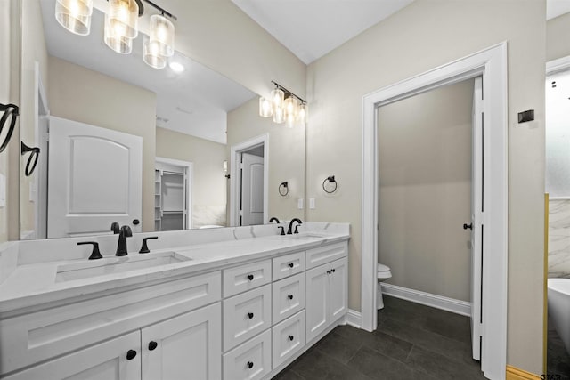 bathroom featuring tile patterned floors, vanity, toilet, and a bathtub