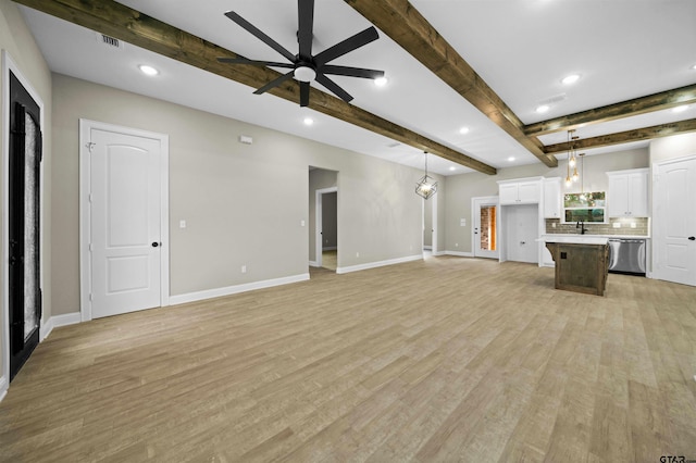 unfurnished living room featuring beamed ceiling, ceiling fan, sink, and light hardwood / wood-style flooring