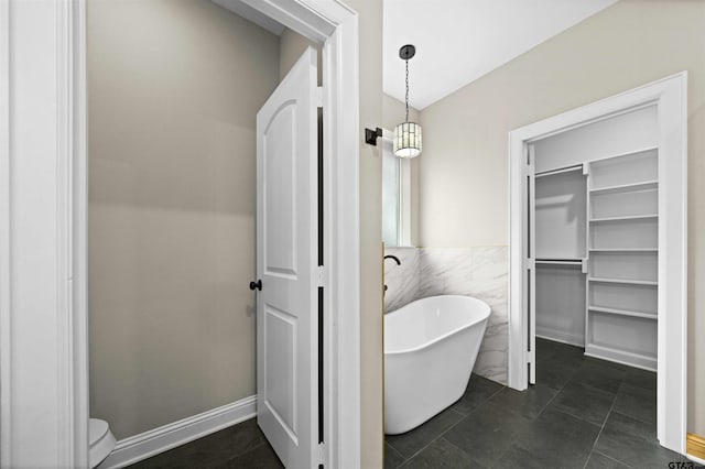 bathroom featuring tile patterned floors, a bathtub, and tile walls