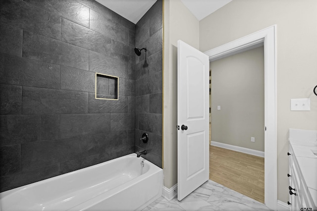 bathroom featuring hardwood / wood-style flooring, vanity, and tiled shower / bath combo