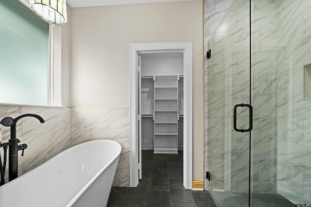 bathroom featuring tile patterned floors, plus walk in shower, and tile walls