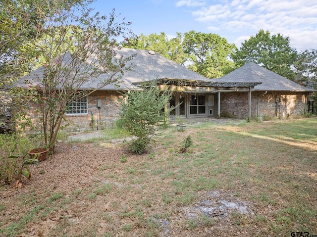 rear view of property featuring a lawn