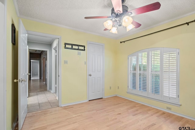 unfurnished bedroom with ornamental molding, a textured ceiling, ceiling fan, and light hardwood / wood-style flooring