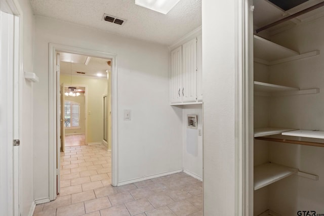 washroom with hookup for a washing machine, a textured ceiling, and light tile patterned floors