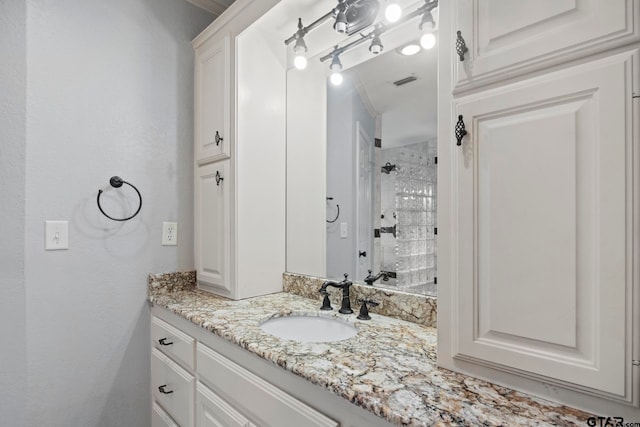 bathroom featuring vanity and a tile shower