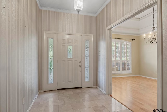 foyer featuring a chandelier, crown molding, and light hardwood / wood-style flooring