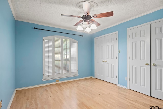 unfurnished bedroom with ceiling fan, light hardwood / wood-style floors, and crown molding