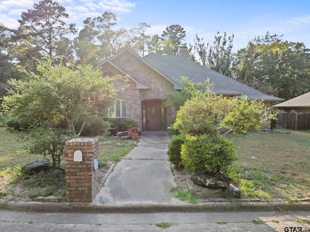 view of property hidden behind natural elements with a front lawn