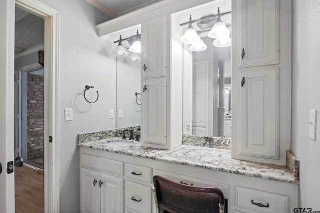 bathroom featuring vanity, hardwood / wood-style flooring, and crown molding